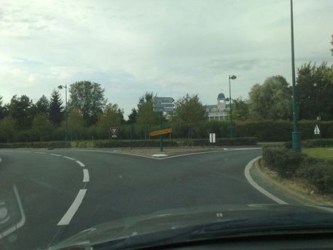 1991 Ford LTD Crown Victoria - Navigating a junction with multiple road signs pointing in different directions.