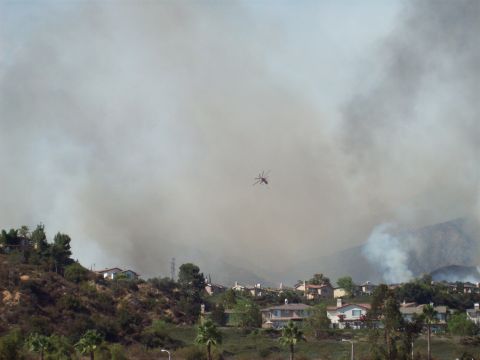 1990 Ford Bronco - A helicopter operates in the sky above houses during a wildfire event.