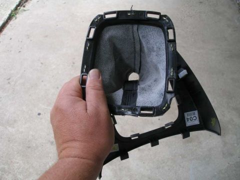 2010 Hyundai Genesis - A car's gear shift boot assembly is held by a hand, showing its internal structure and surrounding trim.