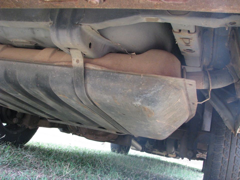 Underside view of a car showing the fuel tank and exhaust system