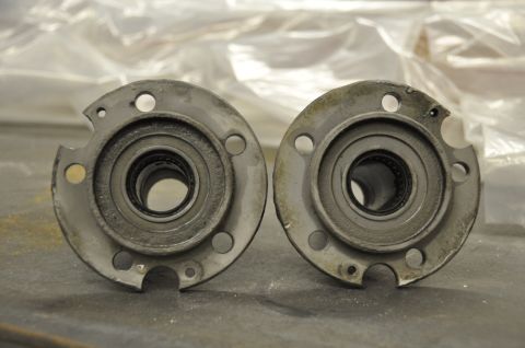 1996 Ford Bronco - Close-up view of two automotive spindle hubs, each containing roller bearings and showing signs of use.