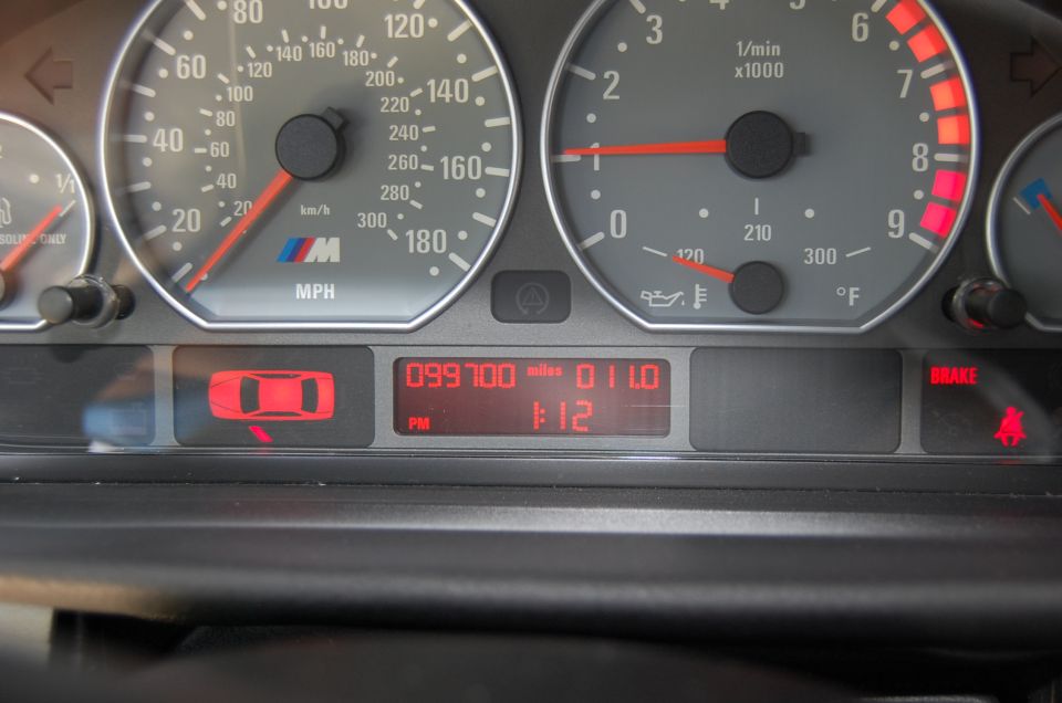 BMW M gauge cluster showing 99,700 miles odometer, speedometer and tachometer