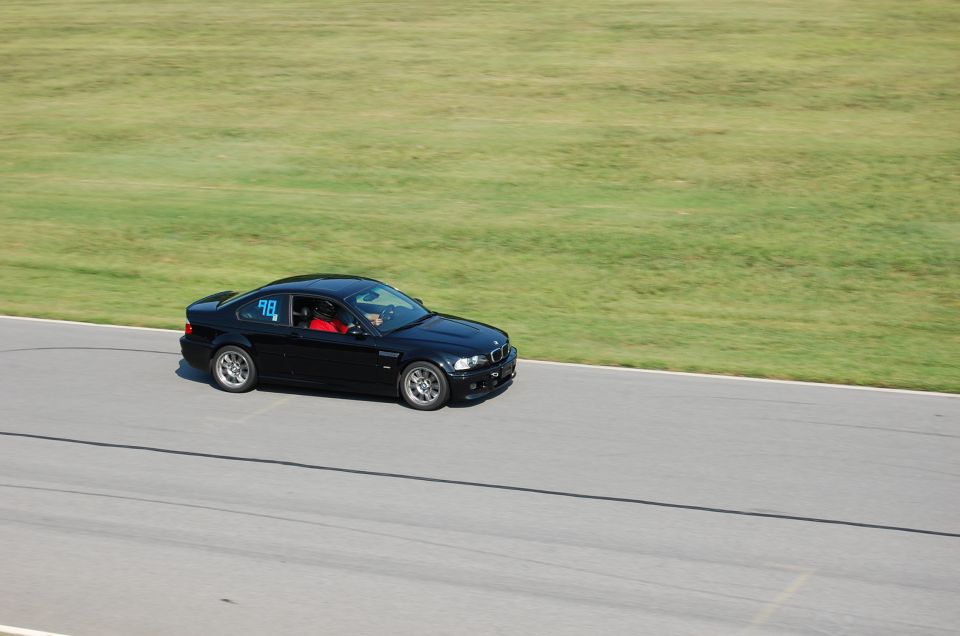 Black 2002 BMW M3 on a racetrack with number 98 on the door
