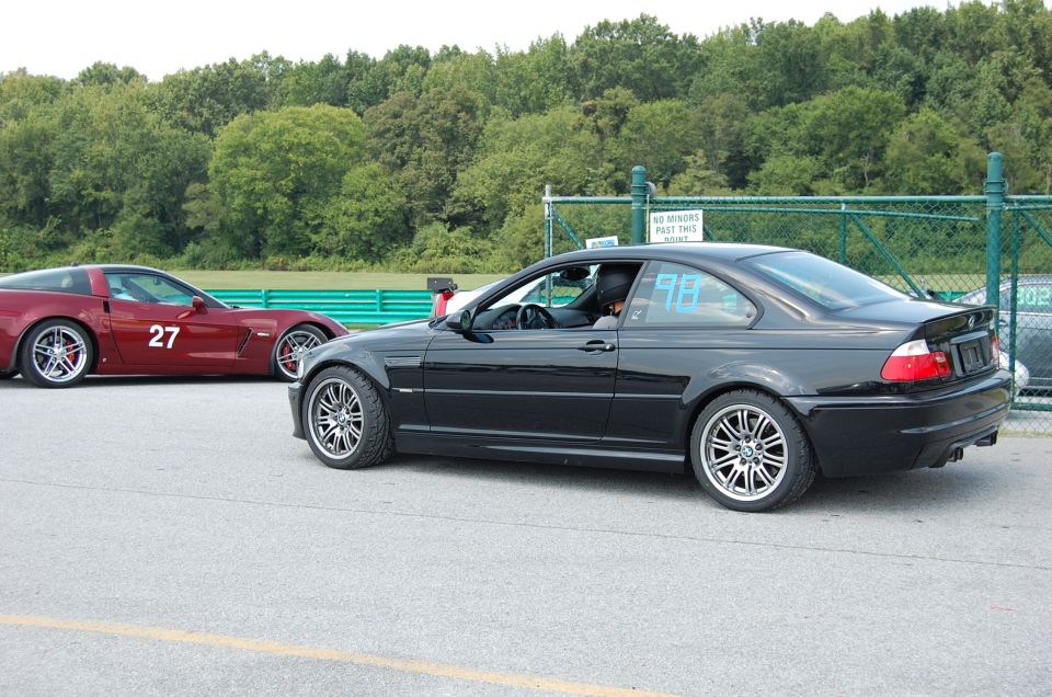 Black 2002 BMW M3 and red Corvette with number 27 on track
