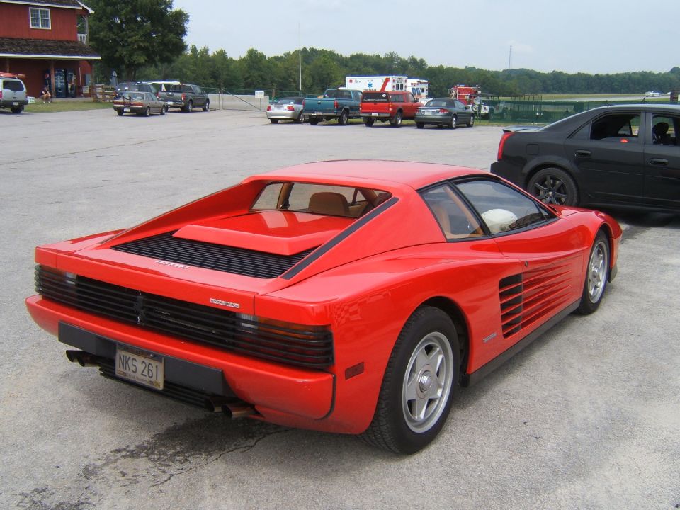 Red sports car with license plate NKS 261 parked on asphalt