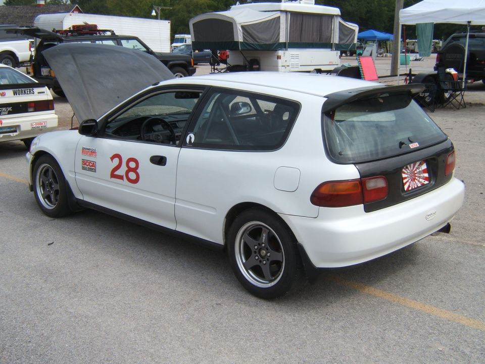 White hatchback with racing number 28 and roll cage