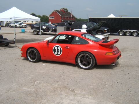 2002 BMW M3 - Red Porsche 911 race car with number 33 on the side is parked at an event.