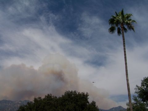 1990 Ford Bronco - A wildfire sends a large smoke plume into the sky, with a helicopter visible near the smoke.