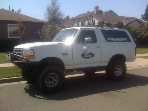 1995 Ford Bronco - This white 1995 Ford Bronco features an aftermarket bumper and a roof rack with lights.