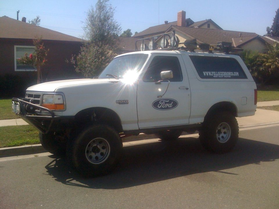 White 1995 Ford Bronco with aftermarket bumper and roof rack