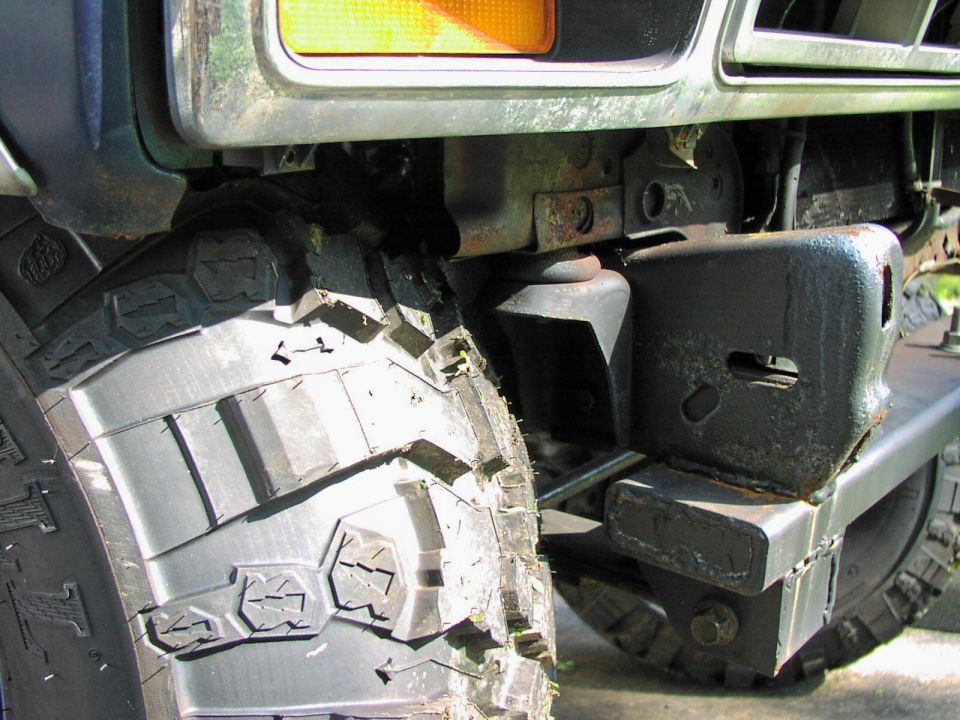 Close-up of a large off-road tire and custom bumper on a vehicle