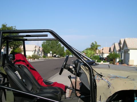 1986 Toyota Hilux - Interior view of a custom off-road vehicle with a roll cage and racing seat.