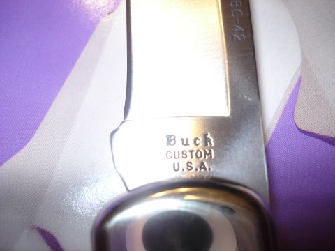 2000 Ford Crown Victoria - A close-up view of a Buck Custom knife blade, marked U.S.A. and BG-42.