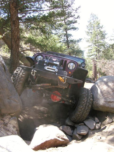 1995 Ford Bronco - A modified Jeep Wrangler navigates a challenging rocky terrain during an off-road excursion.