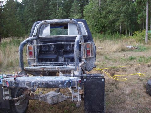 1985 Toyota Pickup/SR5 - Rear view of a 1985 Toyota Pickup/SR5 with a custom flatbed and roll cage installed.