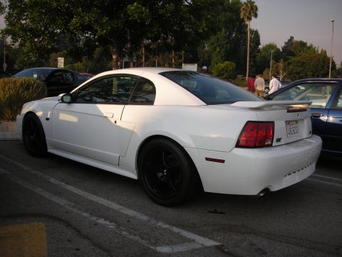 1998 Ford Crown Victoria - A white coupe with black rims and a GT badge is parked in a lot.