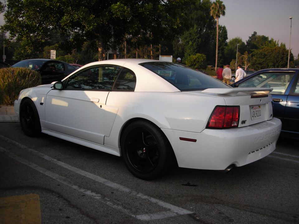 White coupe with black rims and a spoiler. GT badge visible