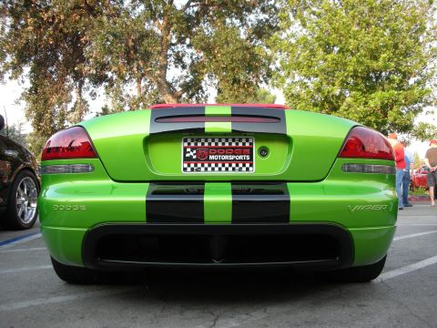 1998 Ford Crown Victoria - A bright green Dodge Viper with black racing stripes is parked outdoors, showing its rear end.