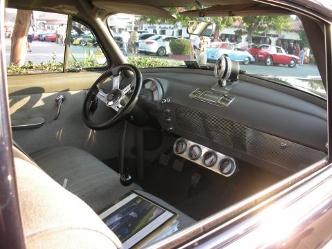 1998 Ford Crown Victoria - Interior of a classic car with aftermarket gauges and a custom steering wheel, parked at an outdoor meet.