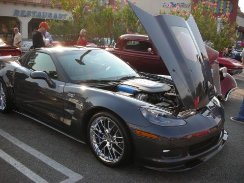 1998 Ford Crown Victoria - Chevrolet Corvette at a car meet, hood raised to display the engine bay.