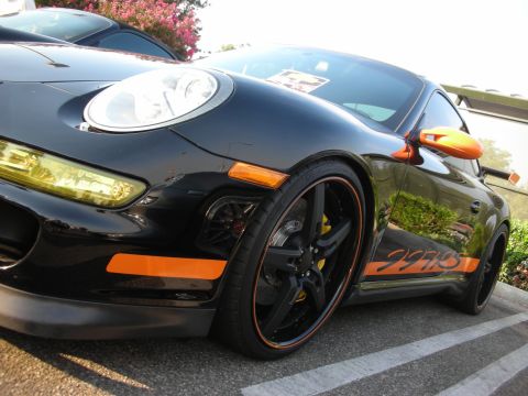 1998 Ford Crown Victoria - Close-up of a black Porsche 911 with distinctive orange racing stripes and accents.