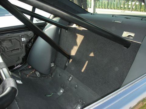 1998 Ford Crown Victoria - Interior view of a car's rear section, modified with a roll cage and stripped-down appearance.