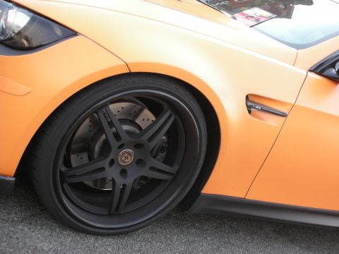 1998 Ford Crown Victoria - The matte orange paint and custom black wheel are visible on this sports car.