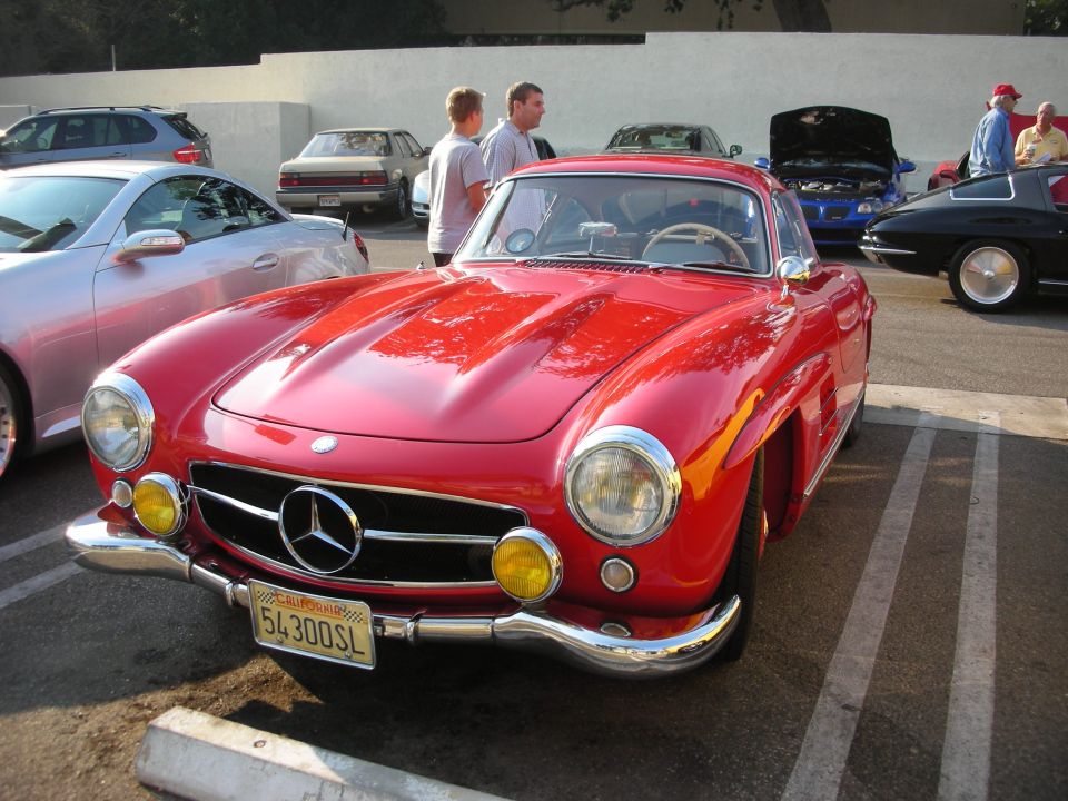 Red 1957 Mercedes-Benz 300SL Gullwing with yellow fog lights and a California license plate reading 54300SL
