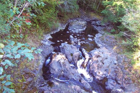 1989 Ford F-150 - A natural scene of a stream cascading over rocks in a wooded area.