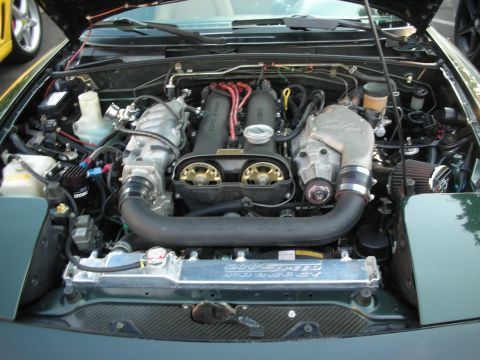 1998 Ford Crown Victoria - The engine bay of a car, a prominent supercharger and a custom radiator with 'Goodspeed Project' visible.