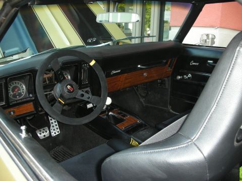 1998 Ford Crown Victoria - The interior of a 1969 Camaro shows woodgrain accents, a custom steering wheel, and a racing seat.