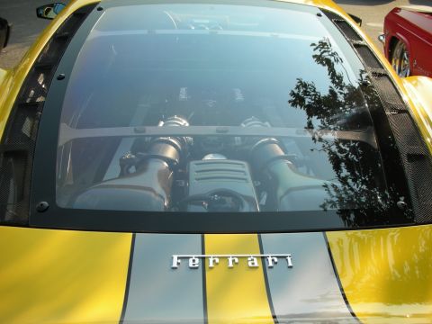1998 Ford Crown Victoria - A yellow Ferrari with racing stripes displays its engine through a glass panel.