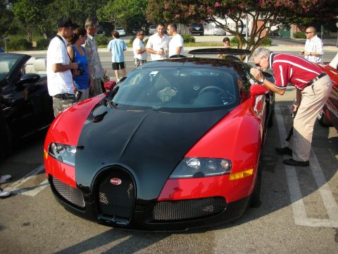 1998 Ford Crown Victoria - A red and black Bugatti Veyron is parked at an outdoor gathering.