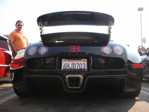 1998 Ford Crown Victoria - A black Bugatti Veyron is seen from the rear, a prominent spoiler and a California license plate.