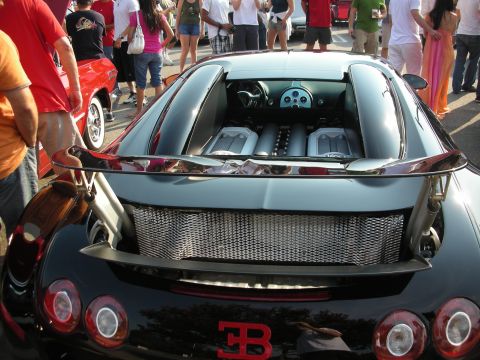 1998 Ford Crown Victoria - A Bugatti Veyron is displayed with its engine cover open, revealing the powerful W16 engine.