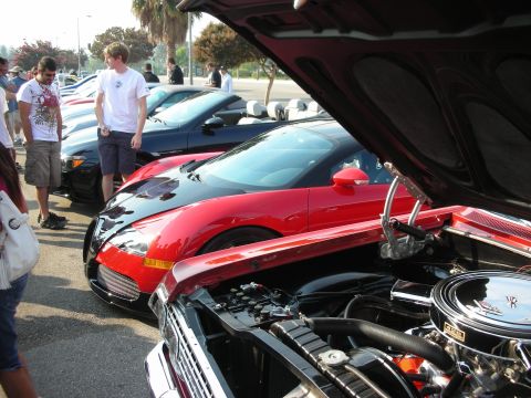 1998 Ford Crown Victoria - A gathering of cars at an outdoor event, various models and attracting onlookers.