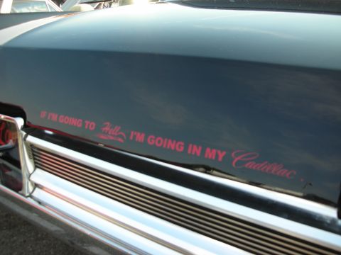 1998 Ford Crown Victoria - A black Cadillac features a red decal on its hood that reads, "If I'm going to Hell, I'm going in my Cadillac."