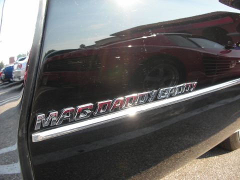 1998 Ford Crown Victoria - Chrome trim with 'MAG DADDY CADDY' text is visible on a dark vehicle's side.