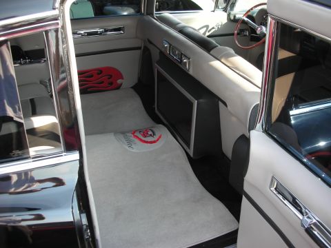 1998 Ford Crown Victoria - The interior features a custom floor mat with the Cadillac emblem and a flame-patterned pillow on the seat.