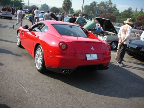 1998 Ford Crown Victoria - A red Ferrari coupe is parked at an outdoor event with several other vehicles and people present.