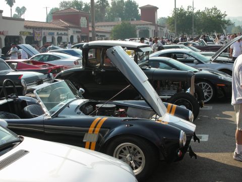 1998 Ford Crown Victoria - A collection of cars are gathered at an outdoor event, with several hoods open.