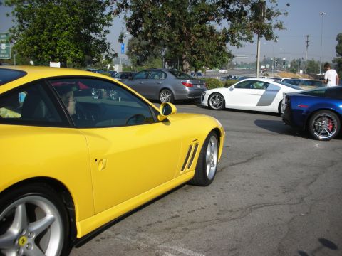 1998 Ford Crown Victoria - Several sports cars, including a yellow Ferrari, a white Audi R8, and a blue Corvette, are parked together.