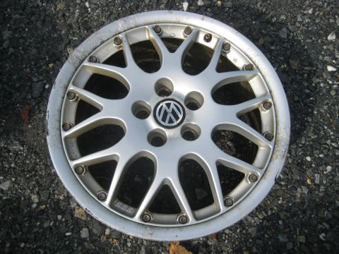 1993 Ford Probe - A single silver BBS alloy wheel with the Volkswagen logo is shown against a dark, gravelly surface.