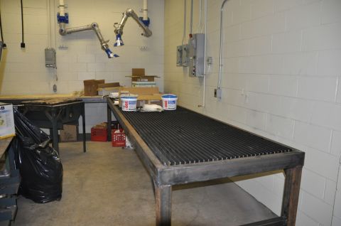 1996 Ford Bronco - A workshop scene with a large cutting table, ventilation arms, and storage boxes.
