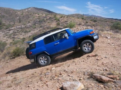 1996 Ford Bronco - Toyota FJ Cruiser navigating rough terrain in a dry, mountainous area.