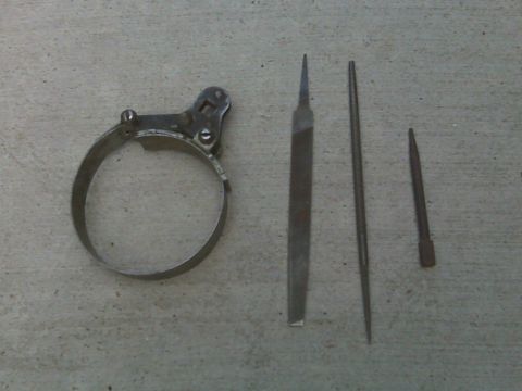 1965 Ford Mustang - A collection of automotive tools, including an oil filter wrench and several files, are laid out on a concrete surface.