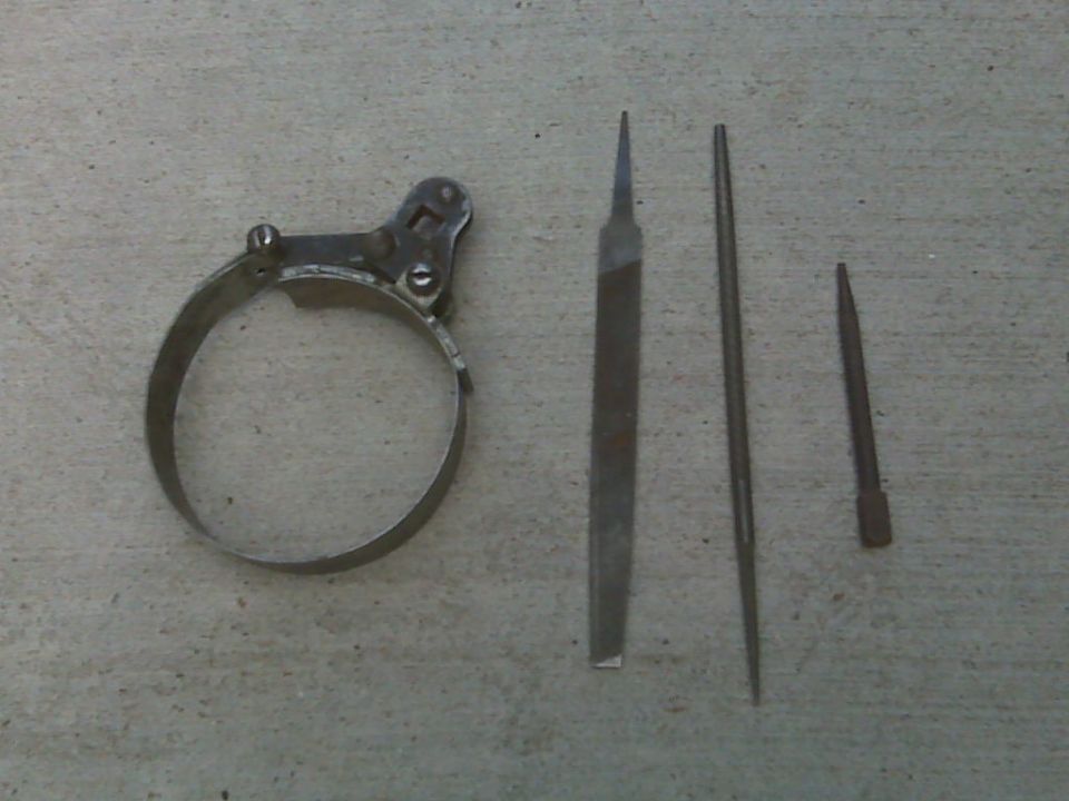 Oil filter wrench and three files on concrete. Supermotors.net logo visible