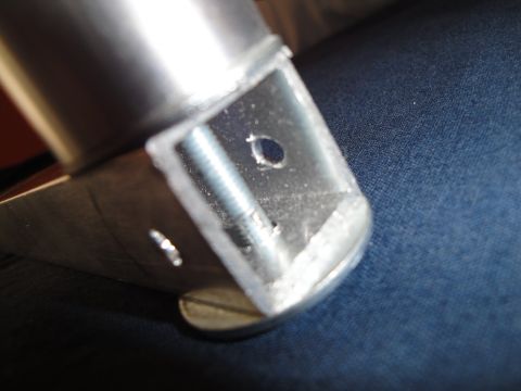 1993 Ford Taurus - Close-up view of a metal bracket with a hole and screw, resting on a blue fabric surface.