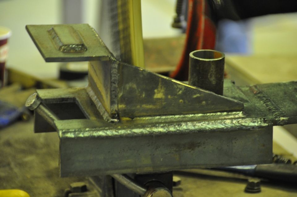 Welded metal bracket with a cylindrical tube attached