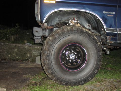 1986 Ford Bronco - Close-up of the front wheel and fender of a blue 1986 Ford Bronco.
